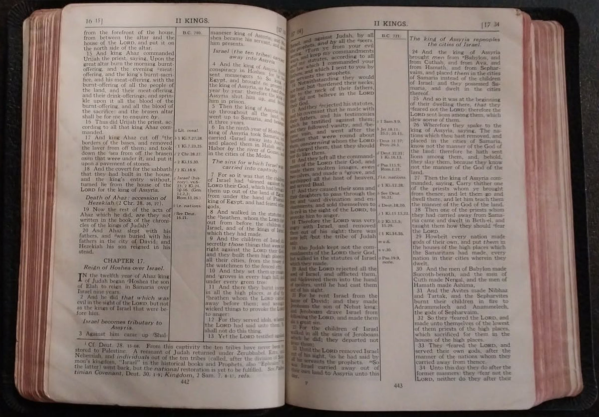 An open vintage dictionary or book with printed text on cream-colored pages, resting on a dark surface.