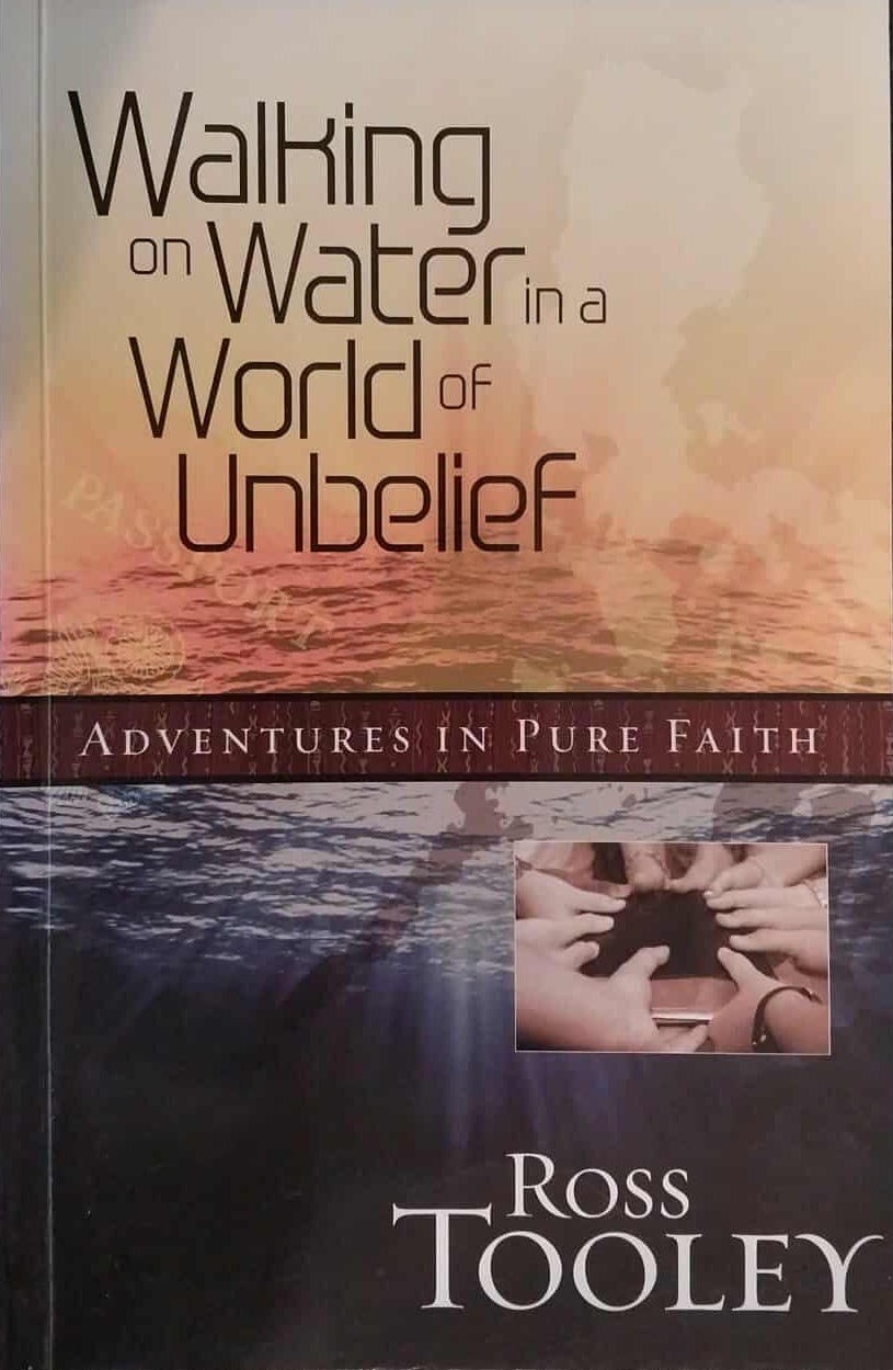 Book titled 'Walking on Water in a World of Unbelief' by Ross Tooley on a dark background