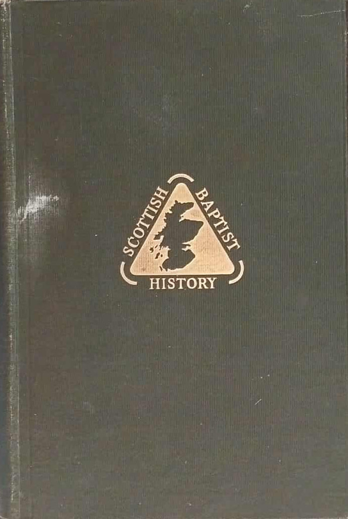 Green book with a logo and text on a dark surface