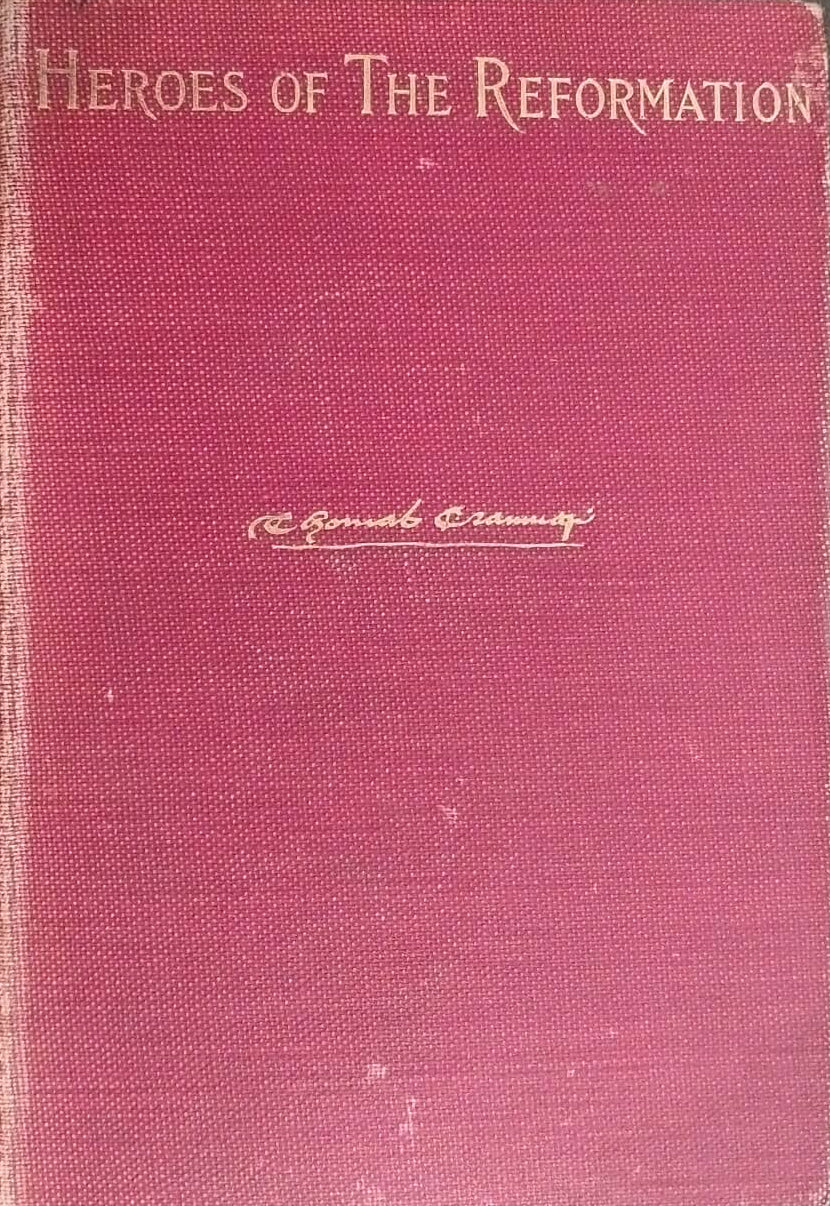 Red book titled 'Heroes of the Reformation' on a dark surface