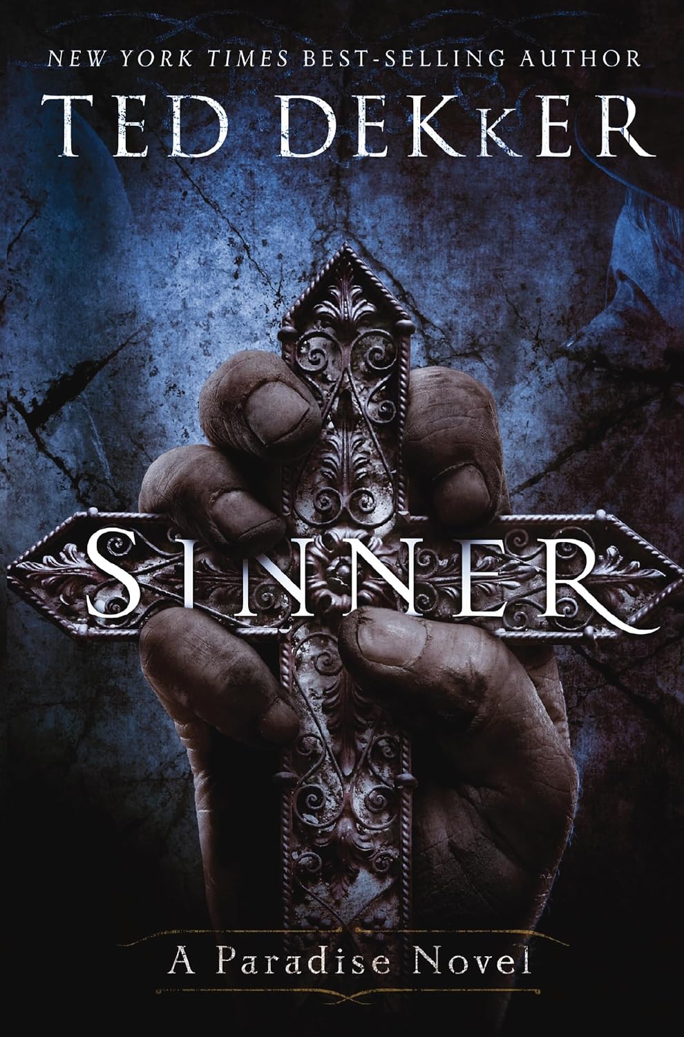 Book cover for 'Sinner: A Paradise Novel' by Ted Dekker, featuring a dark blue textured background, a hand gripping an ornate cross, and the title in large silver lettering across the center.
