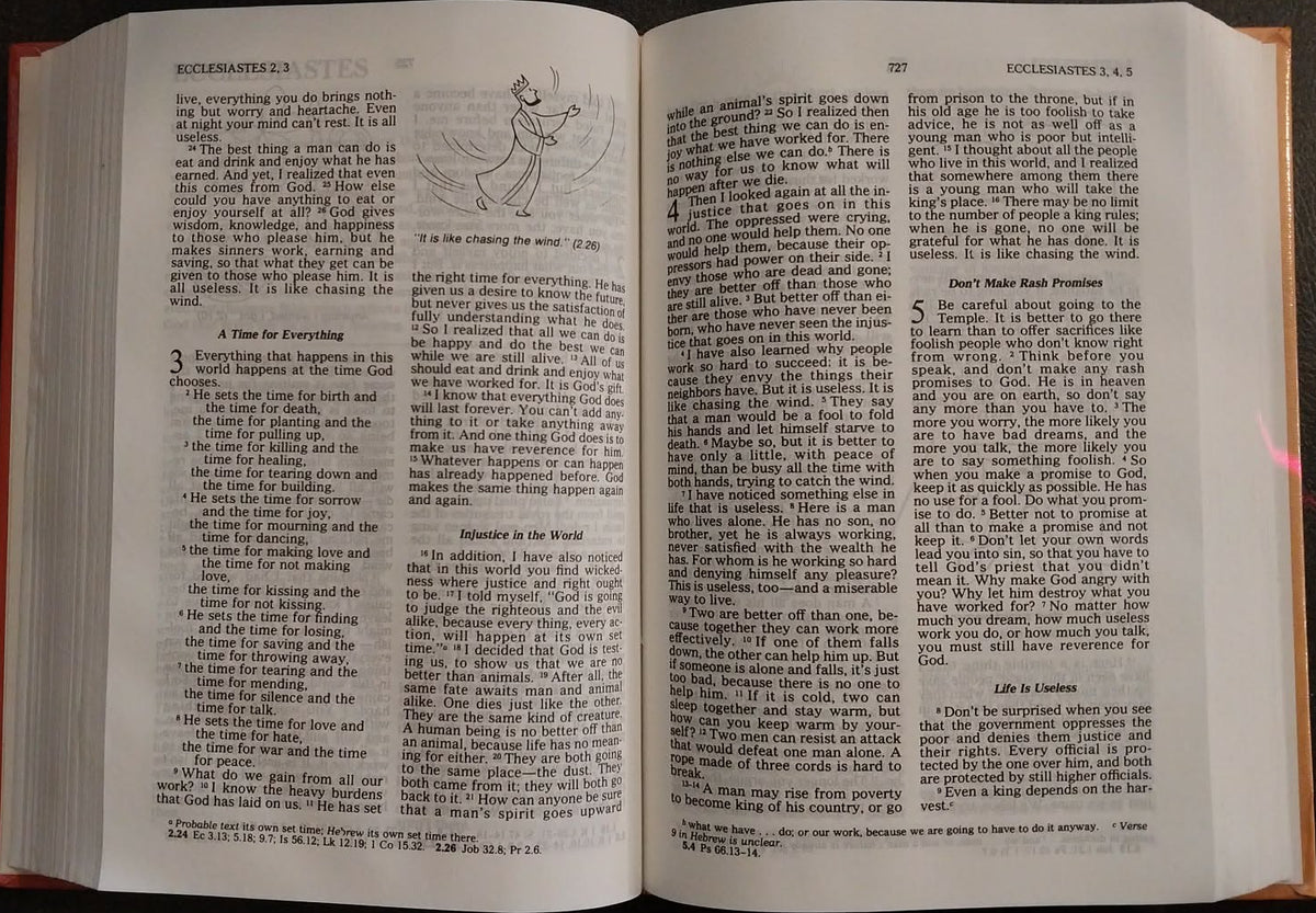 An open book with printed text and a small line drawing on the pages, photographed from above on a dark surface.