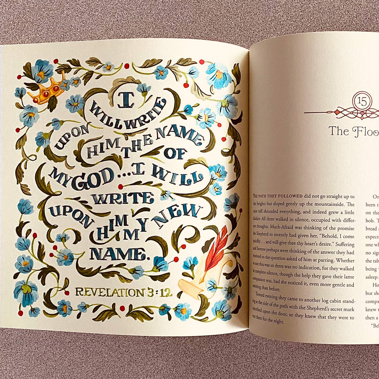 Open book with decorative text and floral elements on a pink background