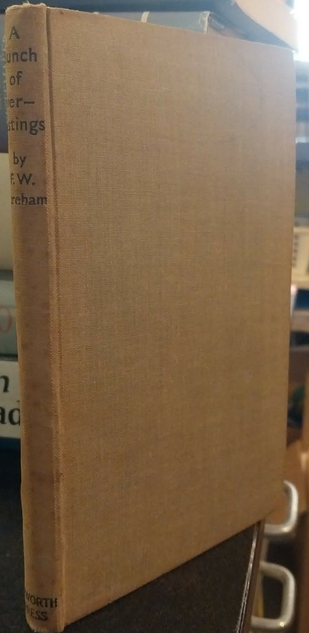 Stack of books on a shelf with a focus on a beige book cover.