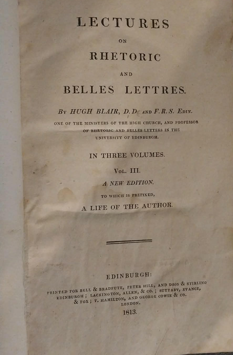 An open vintage book showing the title page of 'Lectures on Rhetoric and Belles Lettres' by Hugh Blair, printed on aged beige paper against a dark background.