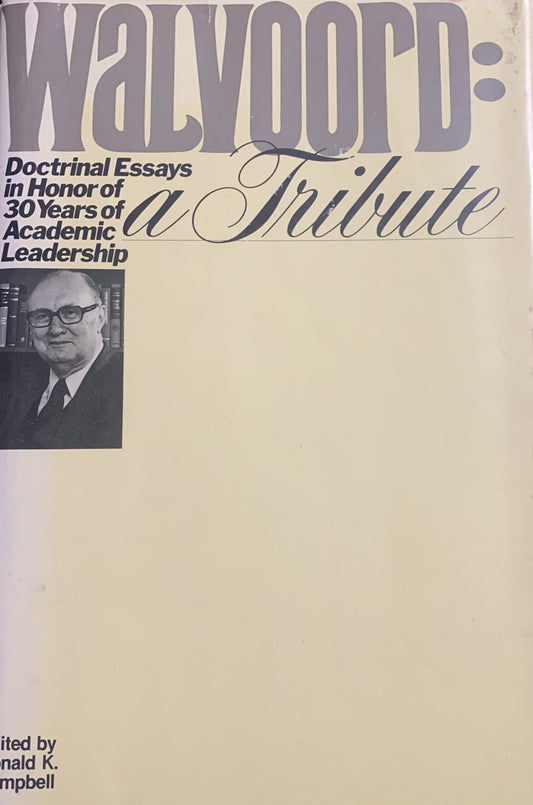 A hardcover book titled 'Walvoord: A Tribute' with a cream-colored cover, large gray title text, black subtitle text, a small black-and-white portrait photo, and editor credit at the bottom, photographed on a dark blue textured fabric background.