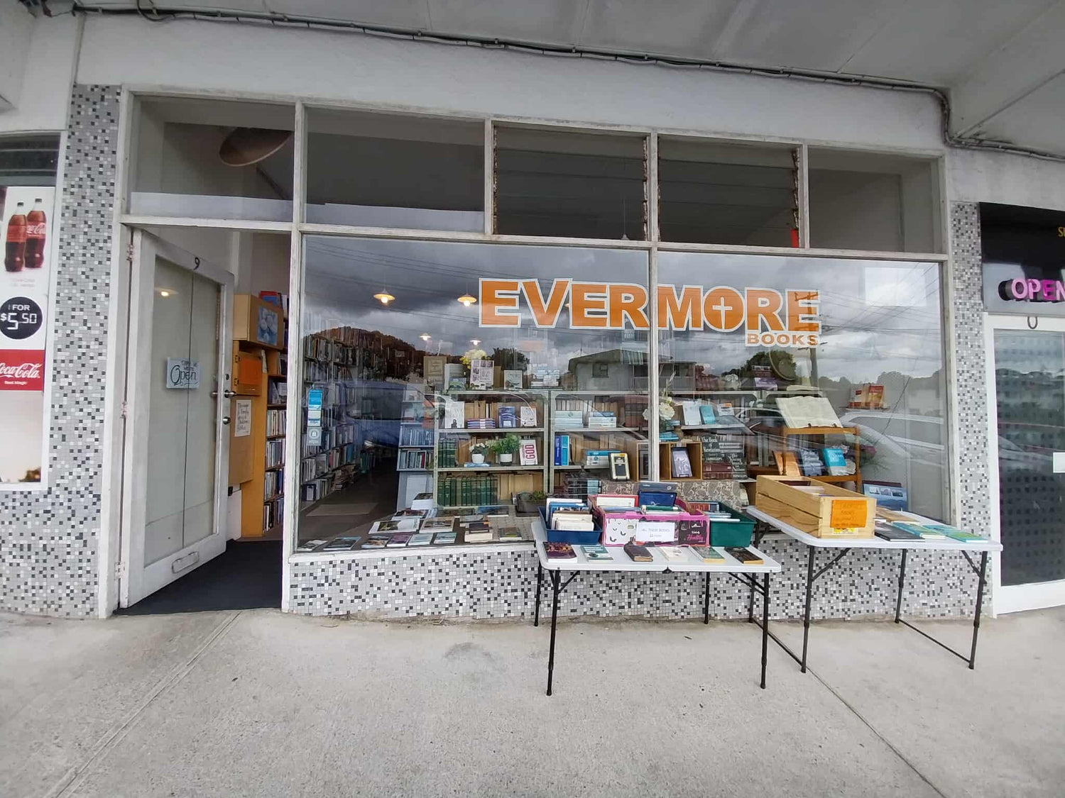 Storefront with 'Evermore' sign and display tables outside