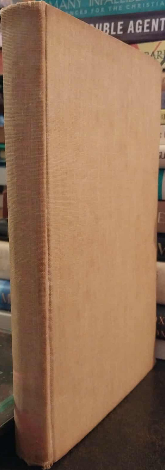 Close-up of a worn book spine with a stack of books in the background