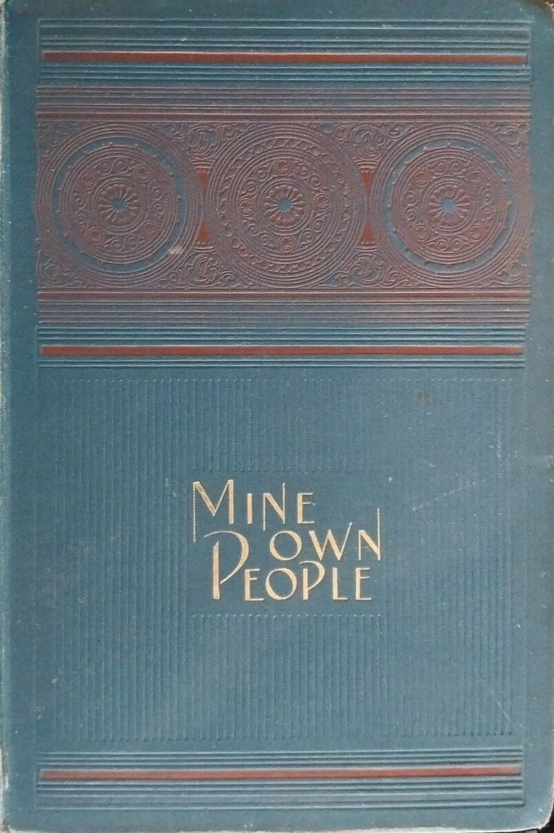 Blue book titled 'Mine Own People' on a dark surface