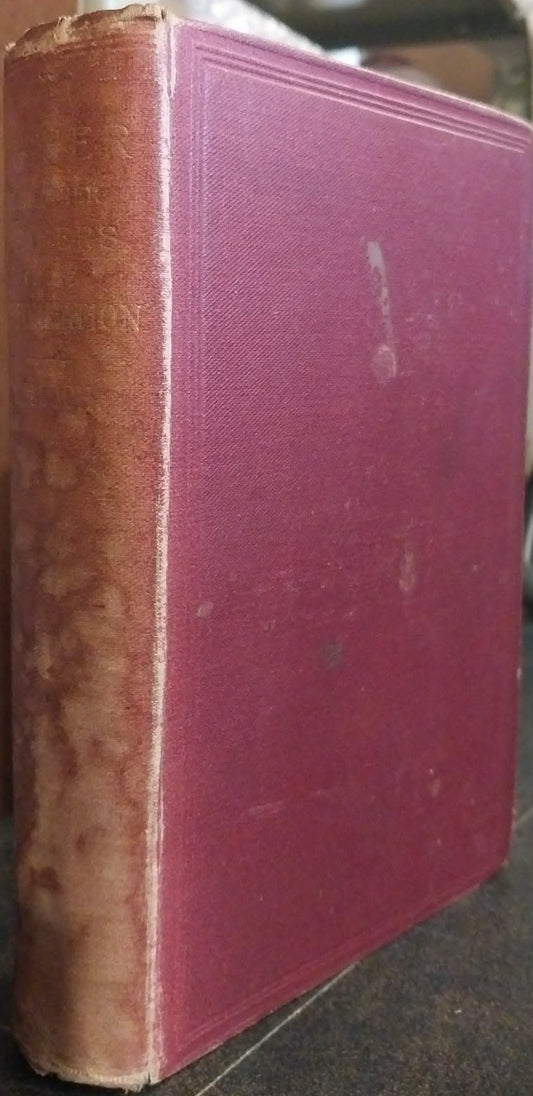 An antique hardcover book with a dusty rose pink front cover and a weathered brown spine, standing upright on a dark surface.