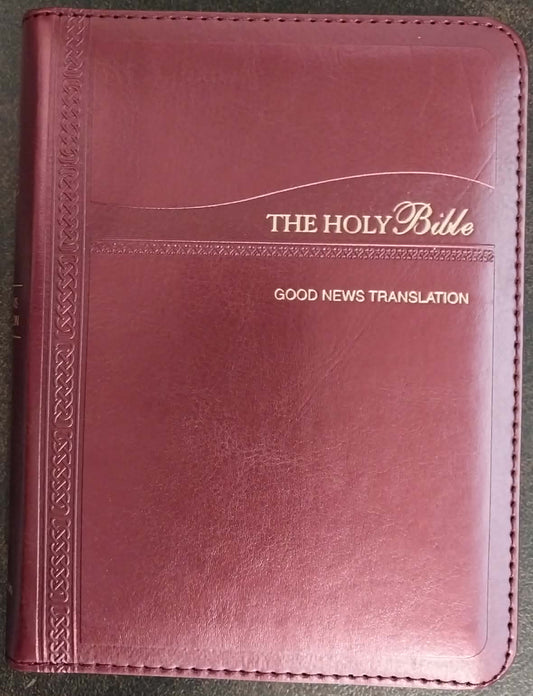 Maroon Bible cover with 'The Holy Bible Good News Translation' text on a dark surface