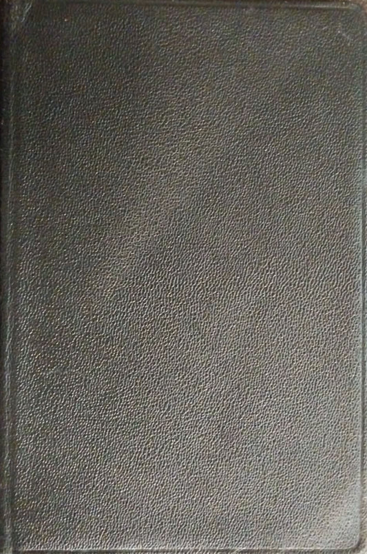 A black textured leather journal or notebook cover shown from a top-down view on a dark brown textured surface.