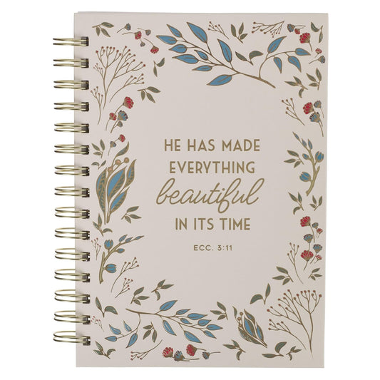 Notebook with floral design and inspirational quote on a white background