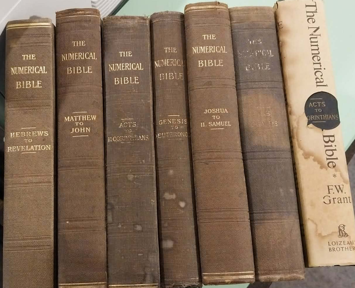 Stack of old leather-bound books on a reflective surface