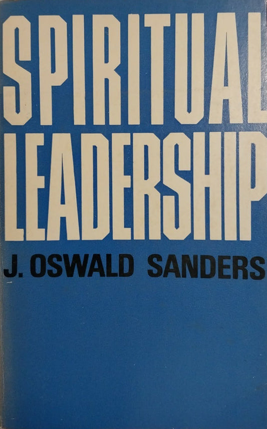 A book titled 'Spiritual Leadership' by J. Oswald Sanders, featuring a blue cover with large white and black text, photographed on top of other books.