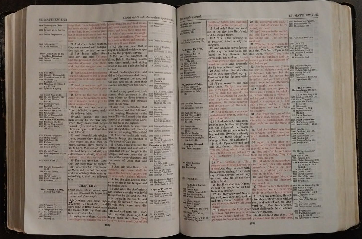 An open printed dictionary or reference book showing two spread pages filled with columns of text and a pink highlighted grid, photographed against a dark background.