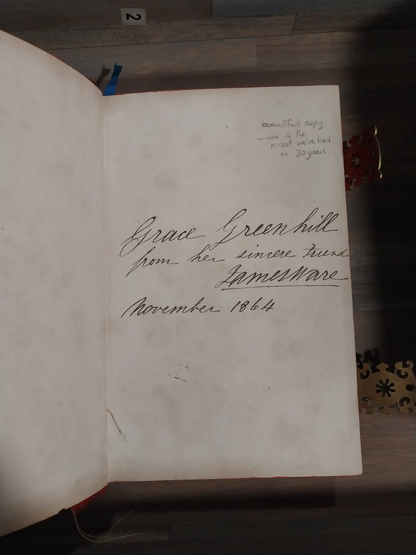 An open vintage book or journal showing an aged, off-white page with handwritten cursive text signed 'Grace Green hill' and dated 'November 1864'.