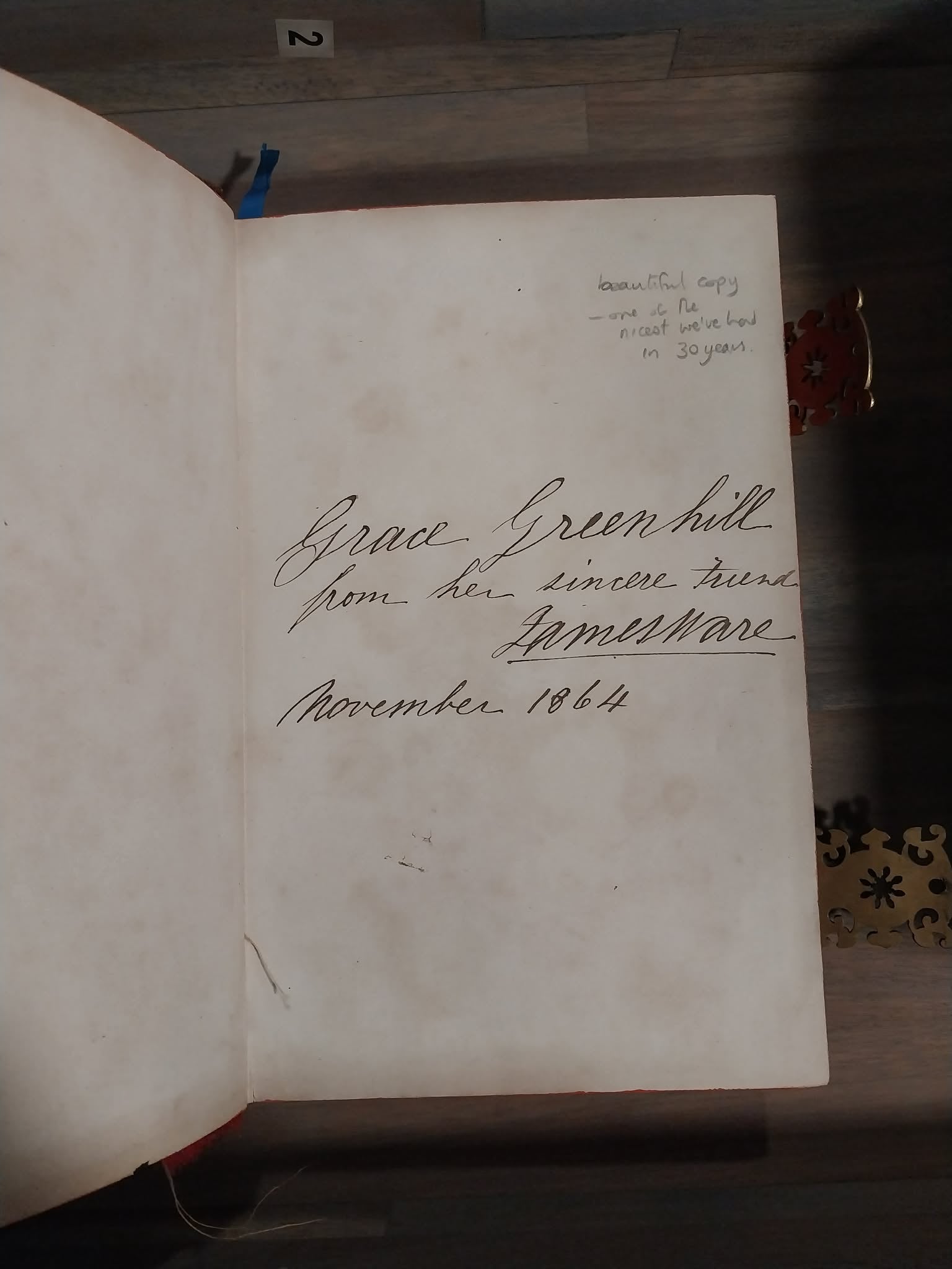 An open vintage book or journal showing an aged, off-white page with handwritten cursive text signed 'Grace Green hill' and dated 'November 1864'.