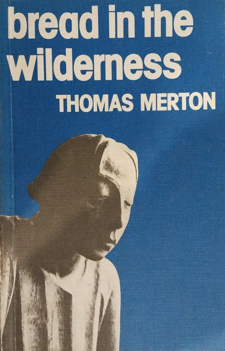 Book cover of 'Bread in the Wilderness' by Thomas Merton with a blue background and silhouette of a person.