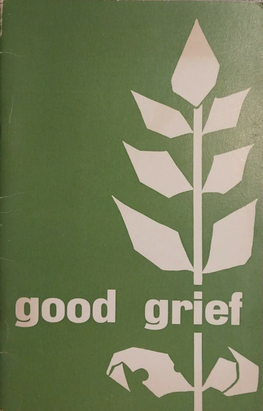 A vintage paperback book titled 'good grief' with a muted green cover and a cream-colored stylized leaf graphic, resting on a surface with other items partially visible.
