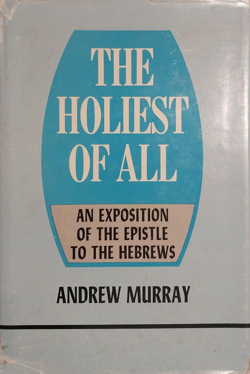 A vintage paperback book titled 'The Holiest of All' by Andrew Murray, featuring a light blue-gray cover with a prominent teal-blue central shield and cream text, photographed on a beige surface.