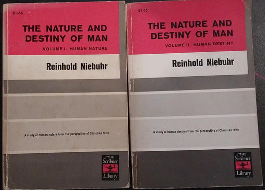 Two copies of 'The Nature and Destiny of Man' by Reinhold Niebuhr on a dark surface.