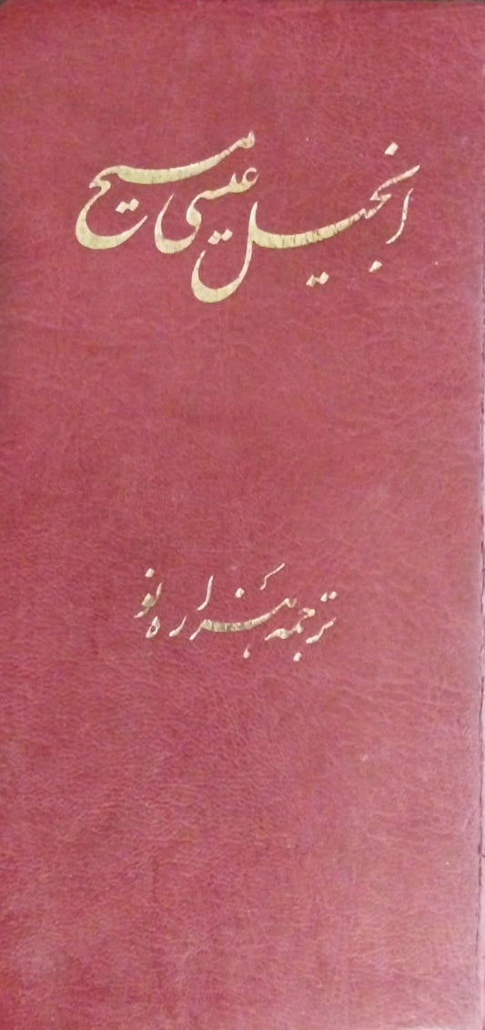 A red hardcover book with gold Arabic calligraphy on the front, photographed from above on a dark textured surface.