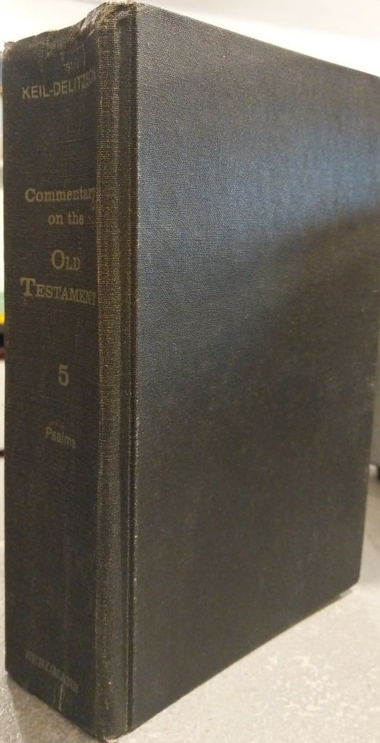 A vintage hardcover book titled 'Commentary on the Old Testament' by Keel-Delitz, standing upright on a tabletop with a blurred indoor background.