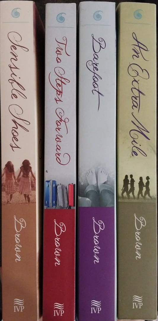 Five books stacked on a surface with a pen and keyboard in the background